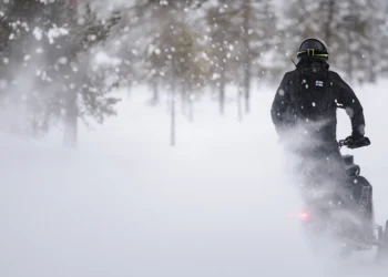Kuva moottorikelkkailijasta kelkkareitillä.