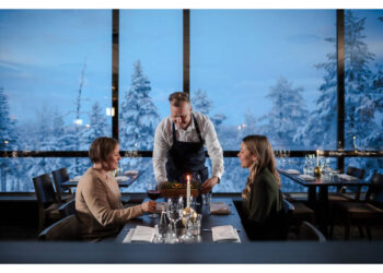 Kuva Lapland Hotels Sky Ounasvaaran ravintolasta, missä on pariskunta syömässä ja tarjoilija